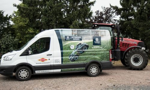 Service- und Lieferfahrzeug von Bockel Landtechnik vor einer Landmaschine.